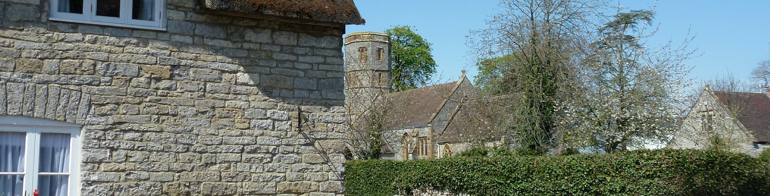 A thatched cottage and church in Somerset. 